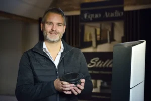 Ivo SPARIDAENS qui tient un haut-parleur Aequo Audio dans ses mains avec une enceinte Stilla à sa droite